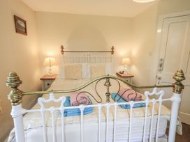 A bedroom with a bed and bedside table at Smithy Cottage at Bowland Bridge Bowness