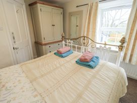 A bedroom with a bed and wardrobe at Smithy Cottage at Bowland Bridge in Bowness