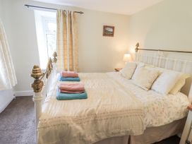 A bedroom with a bed and towels at Smithy Cottage at Bowland Bridge in Bowness