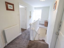 A hallway with a staircase and a radiator at Smithy Cottage at Bowland Bridge Bowness