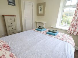 A bedroom with a bed and towels on it at Smithy Cottage at Bowland Bridge Bowness
