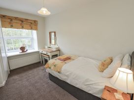 A bedroom with a single bed and a desk at Smithy Cottage at Bowland Bridge Bowness