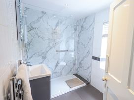 A bathroom with a shower and wash basin at Smithy Cottage at Bowland Bridge Bowness