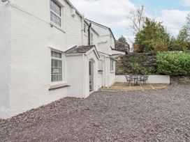 An outdoor area with a patio table and chairs at Smithy Cottage at Bowland Bridge in Bowness