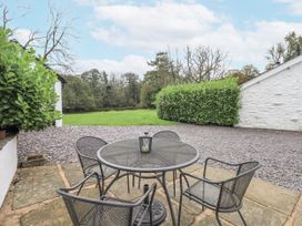 An outdoor seating area with a table and chairs at Smithy Cottage at Bowland Bridge Bowness