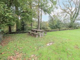 A garden with a picnic table and benches at Smithy Cottage at Bowland Bridge Bowness