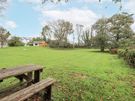 A garden with a table and trees at Smithy Cottage at Bowland Bridge Bowness