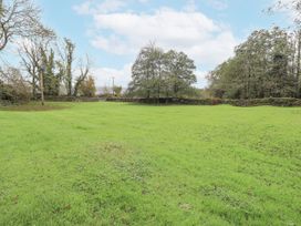 An outdoor area with grass and trees at Smithy Cottage at Bowland Bridge Bowness