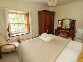 A bedroom with a bed, wardrobe, and dressing table at Beck Steps in Chapel Stile