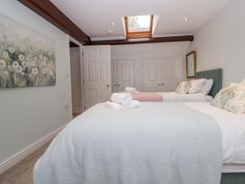 A bedroom with two beds and a painting at Middlerigg in Troutbeck