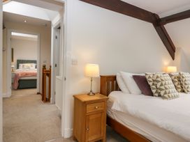 A bedroom with a bed, lamp and doorway to another room at Middlerigg in Troutbeck
