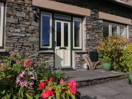An entrance with flowers and a stone wall at Middlerigg in Troutbeck