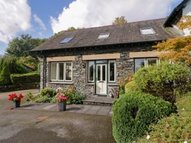 A house with a stone exterior and flowers in planters at Middlerigg in Troutbeck