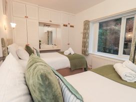 A bedroom with two beds and a window at Fairfield Cottage in Grasmere