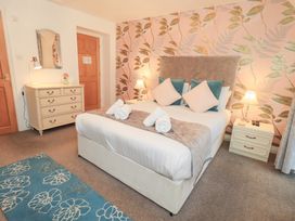 A bedroom with a bed and dresser at Fairfield Cottage in Grasmere