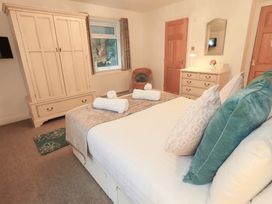 A bedroom with a bed and wardrobe at Fairfield Cottage in Grasmere