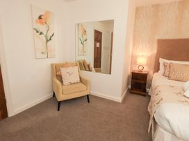 A bedroom with a bed and mirror at Fairfield Cottage in Grasmere