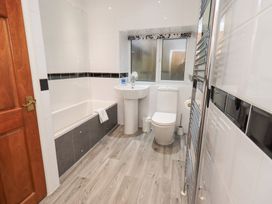 A bathroom with a tub, sink, and toilet at Fairfield Cottage in Grasmere