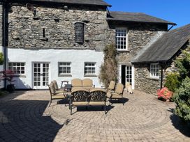 An outdoor patio with chairs and a table at Bank Barn at Rusland in Grizedale