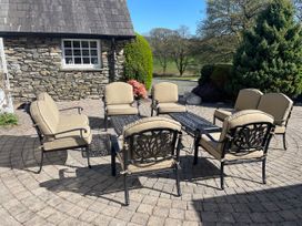 An outdoor seating area with chairs and a table at Bank Barn at Rusland, Grizedale