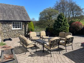 A patio area with furniture and a stone house at Bank Barn at Rusland Grizedale