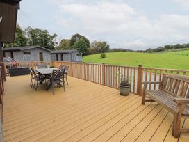 An outdoor deck with a table and chairs at Thie Loghey in Hawkshead