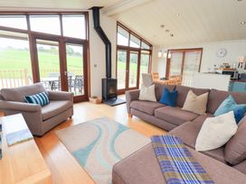 A living room with a sofa and stove at Thie Loghey in Hawkshead