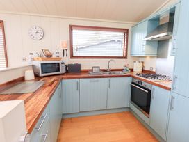 A kitchen with cabinets, stove, and microwave at Thie Loghey in Hawkshead