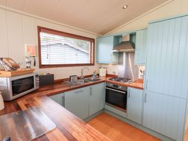 A kitchen with cabinets and appliances at The Loghey in Hawkshead