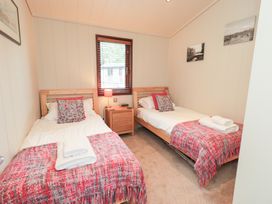 A bedroom with two single beds and a bedside table at Thie Loghey in Hawkshead