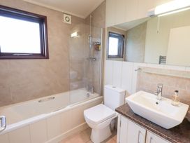 A bathroom with a bathtub, toilet, sink, and shower at Thie Loghey in Hawkshead