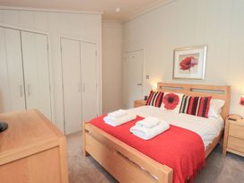 A bedroom with a bed and wardrobe at Thie Loghey in Hawkshead