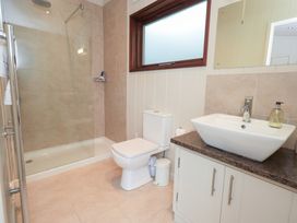 A bathroom with shower, toilet, sink, and cabinet at Thie Loghey in Hawkshead