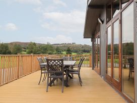An outdoor deck with a table and chairs at Thie Loghey in Hawkshead