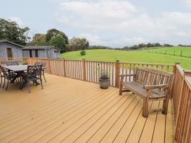 An outdoor deck with a table and chairs and a bench at The Loghey in Hawkshead