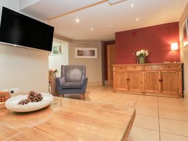 A living room with a television and an armchair at Archie's in Ambleside