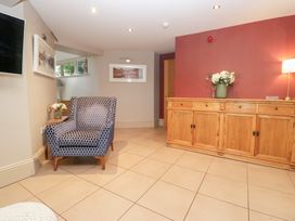 A living room with a chair and table at Archie's in Ambleside