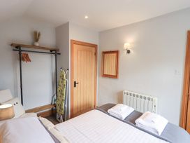 A bedroom with a bed and wardrobe space at Boxwood Cottage in Troutbeck