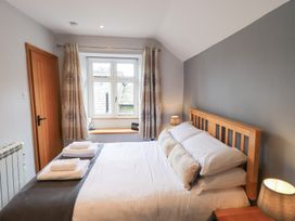 A bedroom with a bed and window at Boxwood Cottage in Troutbeck