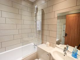 A bathroom with a shower, bathtub, and sink at Boxwood Cottage in Troutbeck