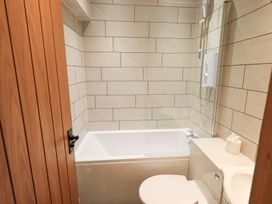 A bathroom with a bathtub and toilet at Boxwood Cottage in Troutbeck