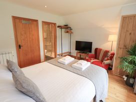 A bedroom with a bed and a television at Boxwood Cottage in Troutbeck