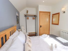 A bedroom with a bed and shelving at Boxwood Cottage in Troutbeck