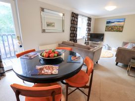 A living room with a dining table and couch at Ghyll Heights in Ambleside