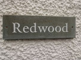 A nameplate with the text Redwood on a wall at Redwood in Ambleside