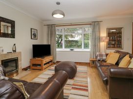 A living room with a sofa, television, and bookshelf at Redwood in Ambleside
