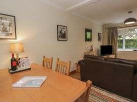 A living room with a table, chairs, and a television at Redwood in Ambleside