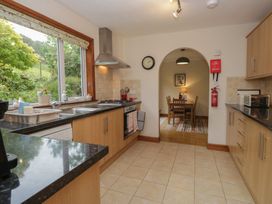 A kitchen with cooking range and dining table at Redwood in Ambleside