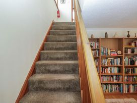 A staircase with a bookshelf and a fire extinguisher at Redwood in Ambleside