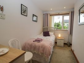 A bedroom with a single bed and nightstand at Redwood in Ambleside
